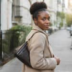 Femme portant pochette peau sombre sur epaule
