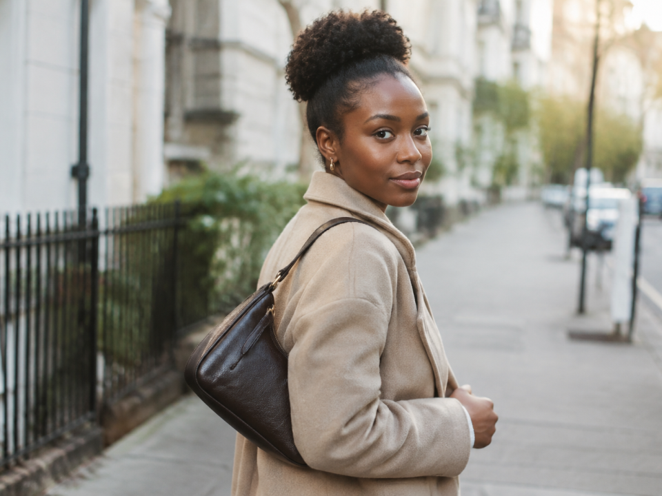 Femme portant pochette peau sombre sur epaule